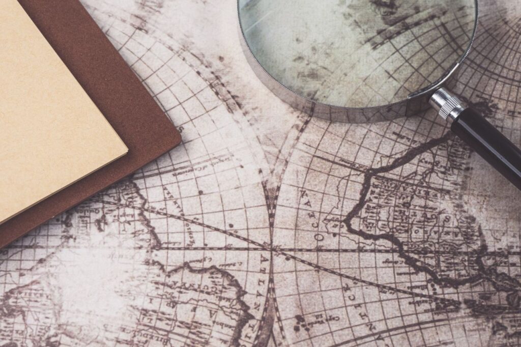 Mastering the First Impression: Your intriguing post title goes here A close-up of a vintage map, magnifying glass, and notebook, perfect for research themes.
